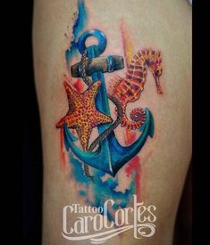 an anchor, seahorse and starfish tattoo on the back of a woman's thigh