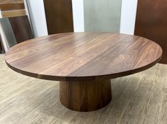 a round wooden table sitting on top of a hard wood floored flooring area