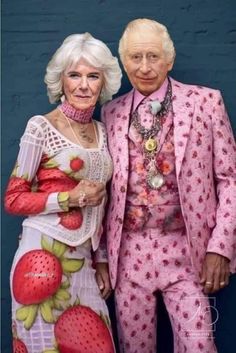 an older man and woman dressed up in matching outfits, posing for a photo together