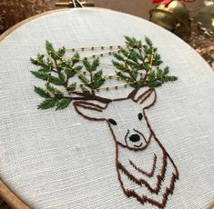 a close up of a embroidery on a piece of cloth with a deer's head