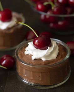 chocolate pudding with whipped cream and cherries on top