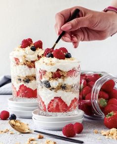 two desserts with berries and granola on the table next to eachother