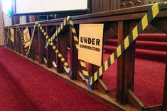 a wooden railing with caution tape around it and a sign that says under construction on it