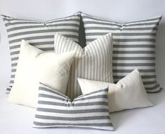 four striped pillows stacked on top of each other in front of a white wall and floor