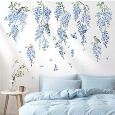 a bedroom with blue flowers and birds on the wall