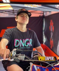 a young man sitting on top of a dirt bike