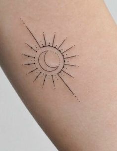 a sun and moon tattoo on the left side of the arm, with small black dots around it