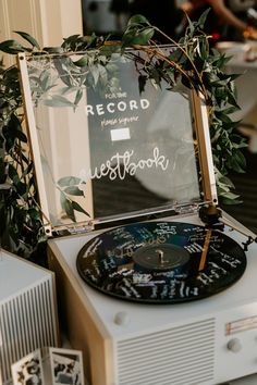 an old record player sitting on top of a table next to a mirror with writing on it