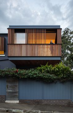 the house is surrounded by greenery and wooden slats