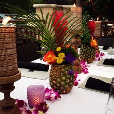 there are pineapples and flowers in vases on the table