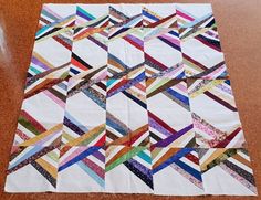 a colorful quilt is laying on the floor with it's edges cut in half