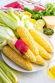 corn on the cob with butter and parsley next to other foodstuffs