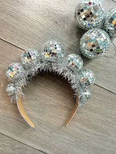 silver disco ball headbands on wooden floor next to christmas balls and tinsel