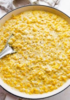 a skillet filled with macaroni and cheese on top of a white table