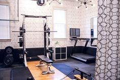 a home gym is shown with equipment in the room and on the wall behind it