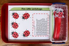 an open book with ladybugs on it and two pencils in the box