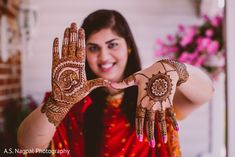 a woman holding her hands up to show the hendi