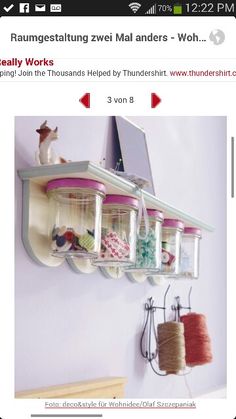 an image of a shelf that is on the wall with some thread and scissors hanging from it