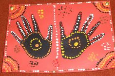 handprints on pink paper with black and white dots in the middle, depicting two hands holding each other