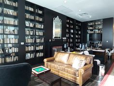 a living room filled with furniture and lots of bookshelves full of bookcases