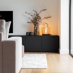 a living room filled with furniture and a vase on top of a wooden table next to a fire place