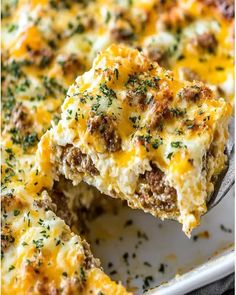 a casserole with meat and cheese on it is being lifted from a baking dish