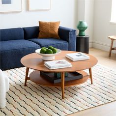 a living room with a blue couch, coffee table and books on top of it