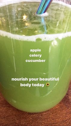 a green cup filled with liquid on top of a wooden table