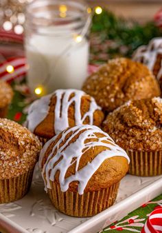 muffins with icing on a white plate next to a glass of milk