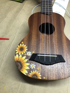 a ukulele with sunflowers painted on it