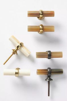 four different types of door handles and knobs on a white surface, one with gold trim