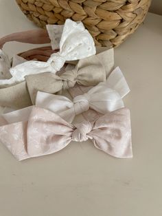 three bows are sitting on a table next to a basket and some other things in the background