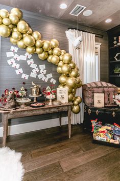 a room with gold balloons and other decorations on the wall, along with an old trunk