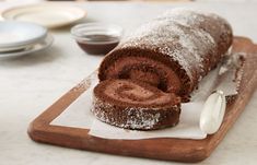 a chocolate roll on a cutting board with powdered sugar