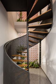 a spiral staircase with wooden handrails in a house