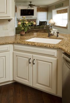 a kitchen with white cabinets and granite counter tops