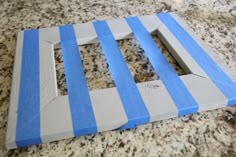 a blue and white striped cutting board sitting on top of a granite counter next to a knife holder