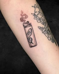 a tattoo with a lighter and butterfly on the left side of the arm that has a snake in it