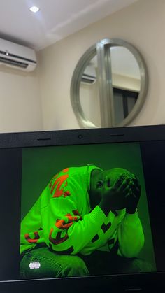 an image of a man in neon green on the screen of a laptop