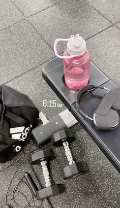 the contents of a gym bag and water bottle are laid out next to each other