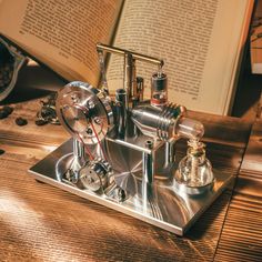 a book is open on top of a table with an old fashioned machine in front of it