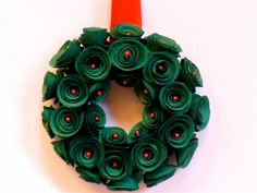 a wreath made out of green paper with red dots on it and an orange marker