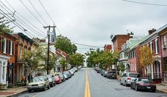 a street lined with parked cars on both sides of it and power lines above them