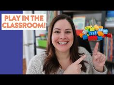 a woman is holding up some legos in front of her and the words play in the classroom