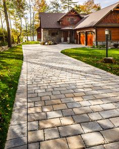 a brick walkway leading to a house in the woods