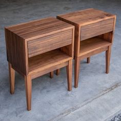 two wooden nightstands sitting side by side on concrete floored area next to each other