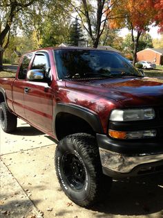 a red pick up truck parked in front of a house