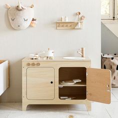 a child's playroom with wooden furniture and toys on the wall, including an animal head