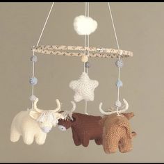 three crocheted animals hanging from a mobile