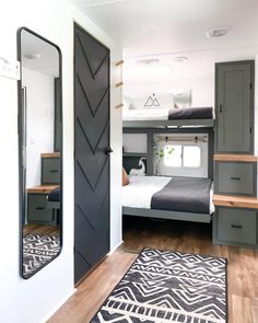 a bedroom with a bunk bed next to a mirror and rug on the floor in front of it